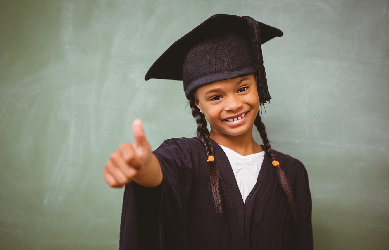 Young child in school graduation gown.