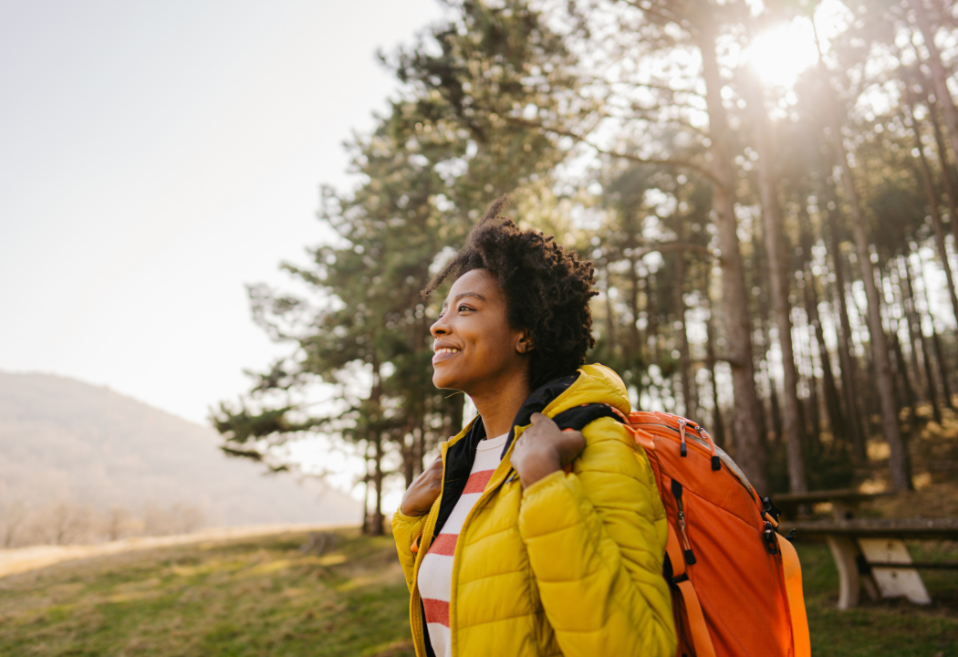 woman backpacking in a yellow jacket