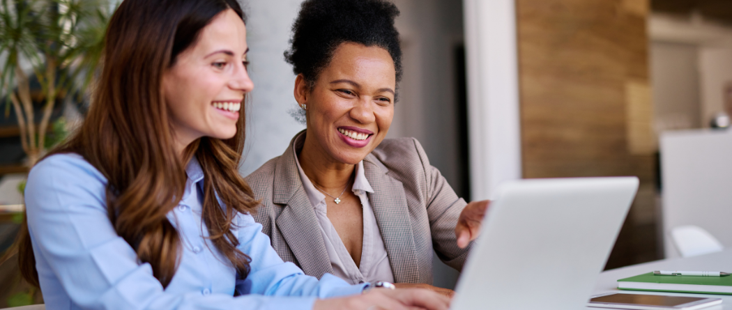 two female coworkers reviewing on a laptop